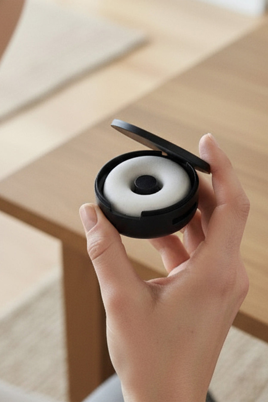 Closeup of a hand holding the Vitruvi Car Freshener